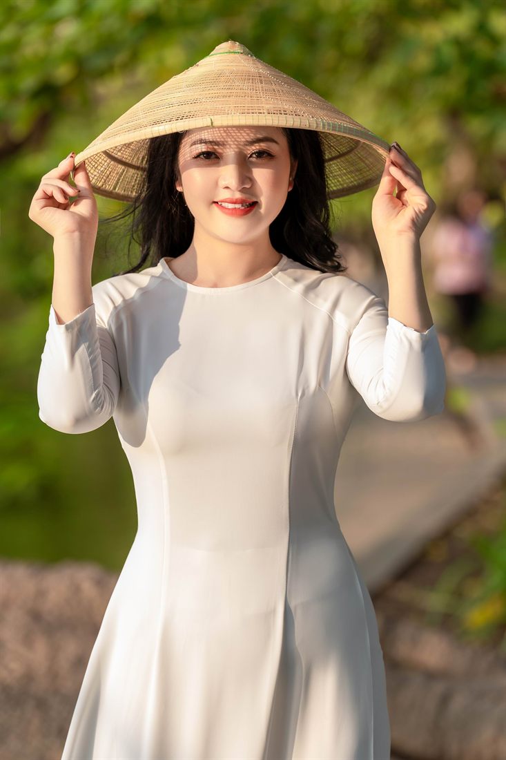 Chân dung áo dài trắng với nón lá dưới nắng