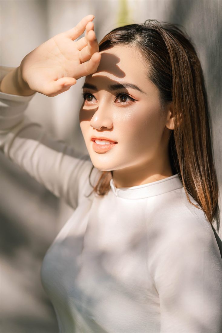 Bóng nắng in trên gương mặt cô gái mặc áo dài trắng