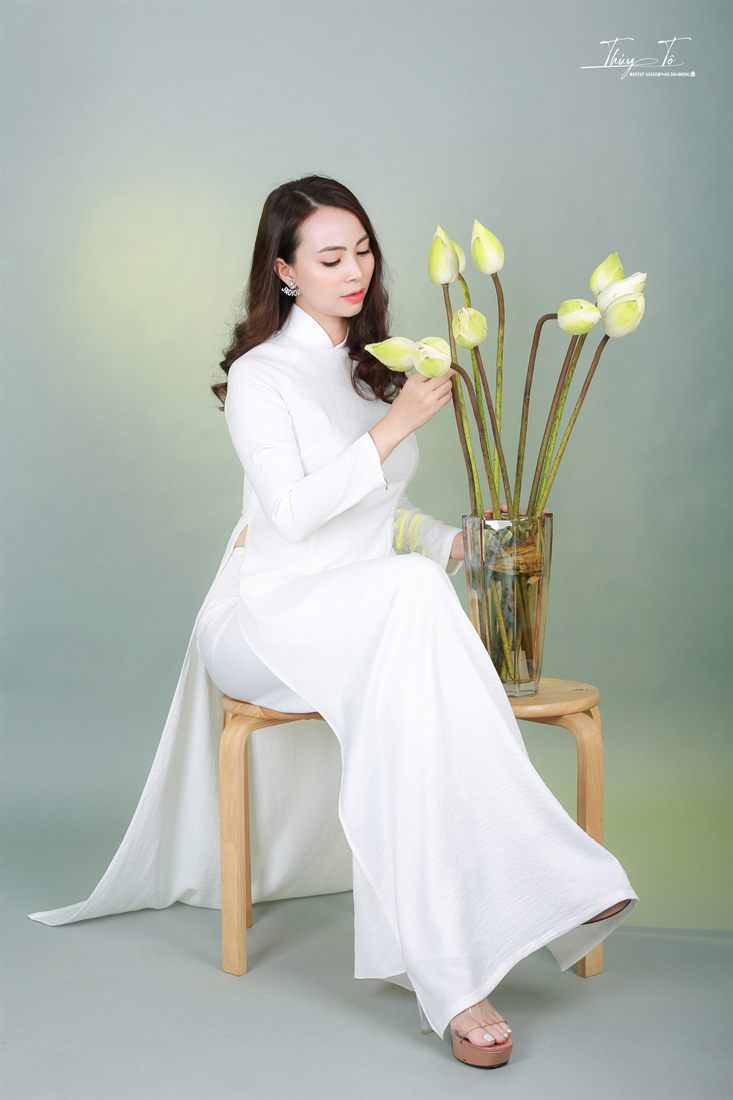 Phòng chụp trong studio với áo dài trắng và bình sen