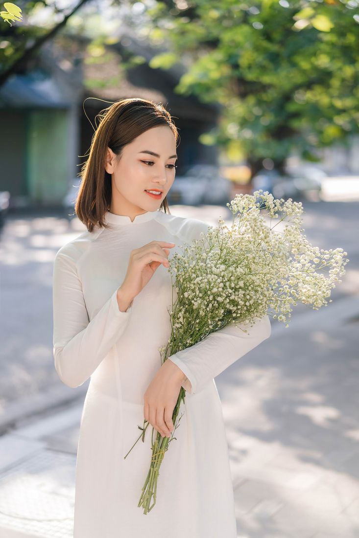 Áo dài trắng ôm hoa baby trên con phố vắng — Thúy Tô Studio